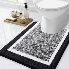 a black and white bathroom rug next to a toilet