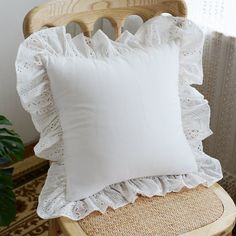 a white pillow sitting on top of a wooden chair