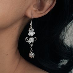 These handcrafted Hmong silver floral earrings are inspired by the traditional Hmong and Miao Minority Tribes jewelry. They are unique and delicate to wear on some occasions such as wedding, birthday party etc. and and would make a lovely gift as well. Materials: s999 Sterling Silver Length: 67mm Drop Length: 49.5mm Width: 16.1mm Weight: 2.7g*2   Cyan Art Store creates dainty jewelry that is inspired by antique and tribal designs from around the globe.   All of our pieces are handmade so keep in Cherry Blossom Earrings, Unique Bridesmaid, Dangle Earrings Silver, Earrings Nature, Flower Dangle Earrings, Silver Flower Earrings, Earrings Unique, Dangly Earrings, Floral Earrings