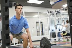 a man is squatting down in the gym