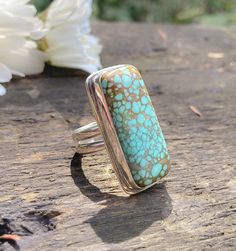 Gorgeous American Super Nova turquoise from Nevada set in a handmade ring I fabricated out of sterling silver. I am in love with rectangular stones, and this big beauty captivated me from the beginning. It's a thick cut stone so it has quite a lovely presence on the ring. The sterling silver band features two separate rings of sterling silver parallel side by side. This is one of my favorite ring band designs to make. The turquoise is a rich aqua color with a light warm brown matrix. The ring face measures just over 1.25 inches tall. Comfortably fits a size 8.25 to an 8.5. I list the size variation, because it depends on which way you wear the ring. It's slightly tighter in one direction than the other. Signed ghostdog 925. Polished to a glowing satin finish. Artisan Turquoise Rectangular Jewelry, Rectangular Turquoise Sterling Silver Ring, Unique Rectangular Turquoise Ring, Handmade Turquoise Rectangular Rings, Handmade Silver Turquoise Ring With Rectangular Shape, Bohemian Sterling Silver Ring With Rectangular Shape, Silver Rectangular Turquoise Gemstone Ring, Unique Sterling Silver Ring With Rectangular Stone, Handmade Silver Rectangular Turquoise Ring