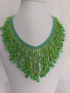 Embrace the enchanting allure of my 'Tropical Breeze Green & Turquoise Harmony Seed Bead Branching Waterfall' necklace! Handcrafted with love, this mesmerizing piece boasts a cascade of vibrant green and turquoise seed beads complemented by green stone chips, creating a stunning visual symphony. Each bead is meticulously threaded with quality beading thread, ensuring durability and lasting beauty. The necklace is adorned with a gold-plated lobster clasp and an extension chain, allowing a customizable length of 47 cm. At its longest drop, it gracefully extends 18 cm, adding a touch of elegance to any ensemble. Elevate your style with this radiant, nature-inspired creation. Turquoise Beaded Dangle Necklaces, Bohemian Beaded Necklaces For Beach With Polished Beads, Green Round Bead Necklaces For The Beach, Beaded Turquoise Necklace With Round Beads For The Beach, Handmade Green Bohemian Beaded Necklaces, Green Beach Necklace With Colorful Beads, Green Dangling Beads For Festival, Green Polished Beaded Necklace For Festival, Green Polished Beads Necklace For Festivals