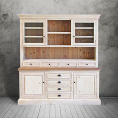 an old white china cabinet with drawers and cupboards on the top, against a gray wall