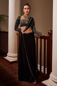 Black pre-draped saree with placement hand embroidery and a show ring placed at the waist. Paired with a blouse with all over hand embroidery using shimmering stones, sequins, beads and cutdana.
Components: 2
Pattern: Hand Embroidery
Type Of Work: Sequins, Stones, Cutdana
Neckline: Sweetheart Neck
Sleeve Type: Full Sleeves
Fabric: Saree: Crepe, Blouse: Dola Silk 
Color: Black
Other Details: 

Note: All the jewellery worn by the model is not for sale
Occasion: Cocktail - Aza Fashions Traditional Pre-draped Saree With Zari Work For Evening, Traditional Evening Pre-draped Saree With Zari Work, Festive Evening Pre-draped Saree With Cutdana, Formal Embellished Pre-draped Saree For Diwali, Traditional Evening Blouse Piece With Traditional Drape, Traditional Drape Evening Blouse Piece, Traditional Festive Pre-draped Saree For Evening, Traditional Evening Pre-draped Saree, Evening Sharara With Zari Work In Traditional Drape