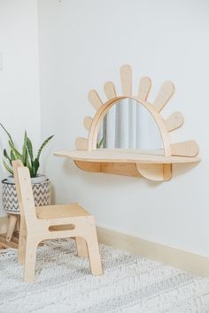 a wooden chair sitting next to a mirror on a wall near a potted plant