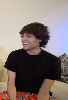 a young man sitting on top of a couch