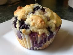 a blueberry muffin sitting on top of a white plate