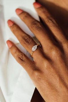 a woman's hand with a diamond ring on top of her left hand and napkin in the background