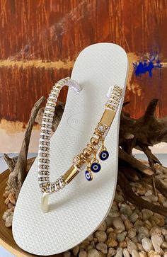 Get ready to fall in love with this fancy Design by Desire Flip Flops. Rich ornaments and elegant color make this sandals perfect to accompany you in unique and stylish looks.All sandals are handcrafted with the finest Brazilian embellishments. We use the original Havaianas®️: thong style made in Brazil 100% rubber non slip tread durable and flexible Customized items are final sale so they can’t be returned. Elegant Beaded Beach Sandals, Elegant Beaded Sandals For Beach, Elegant Beaded Sandals For Festival, Luxury Gold Sandals With Adjustable Fit, Luxury Gold Adjustable Sandals, White Bohemian Sandals For Party, Luxury Adjustable Gold Sandals, Elegant Gold Sandals For Festivals, Bohemian Embellished Party Sandals