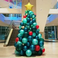 a christmas tree made out of balloons in a lobby