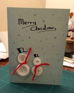 a christmas card with two buttons attached to it