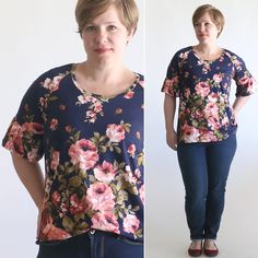 a woman standing in front of a white wall wearing jeans and a flowered top