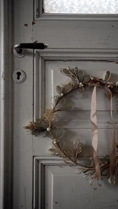 a wreath hanging on the front door of a house