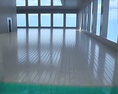 an empty room with large windows overlooking the ocean