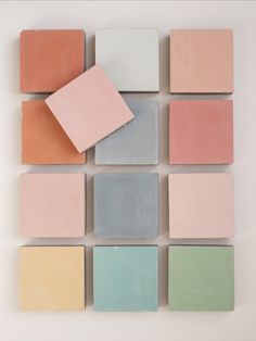 several different colors of soap sitting on top of each other in a square formation,