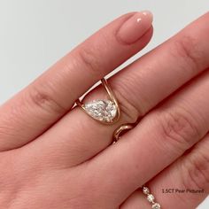 a woman's hand with a ring on it and a diamond in the middle