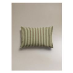 a green and white striped pillow sitting on top of a wall