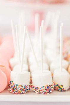 marshmallows and sprinkles are arranged on a white platter