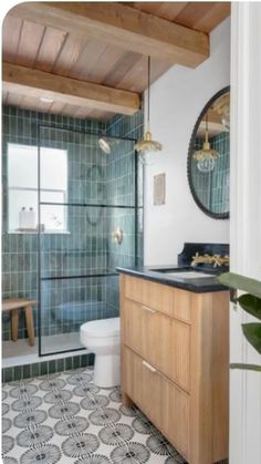 a bathroom with green tile and wood accents