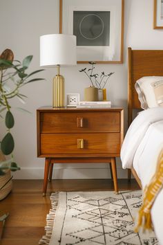 a bedroom with a bed, nightstand and pictures on the wall