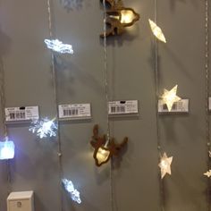 some lights are hanging on the wall with tags attached to it's sides and stars