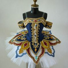 a mannequin is adorned with gold, blue and red beaded dress material