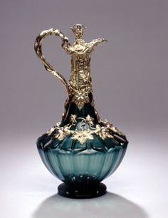 a green glass vase with gold decoration on it