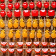 there are many red and yellow candies in the shape of pineapples on display