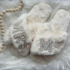 a pair of white slippers with the word mr and mrs on them are laying on a fur rug