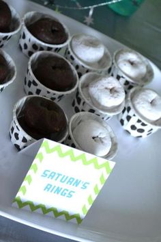 cupcakes with white frosting and green chevron paper wrappers on a tray