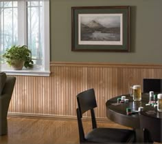 there is a table and chairs in this dining room with wood paneling on the walls