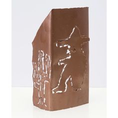 a piece of chocolate that has been carved into the shape of a house with a dog on it