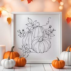 three pumpkins are sitting in front of a white frame