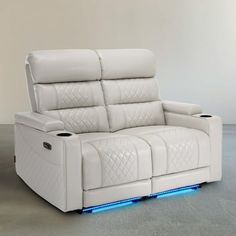 a white leather reclining couch with blue lights on the arm and headrests