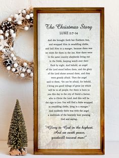 the christmas story is displayed in front of a wreath and a small pine tree on a shelf