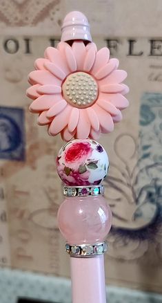 a pink toothbrush holder with three flowers on it