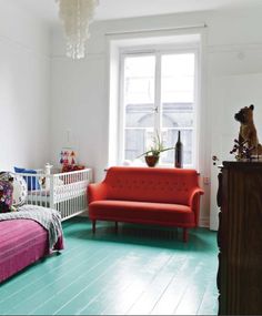 a living room filled with furniture and a red couch in front of a large window