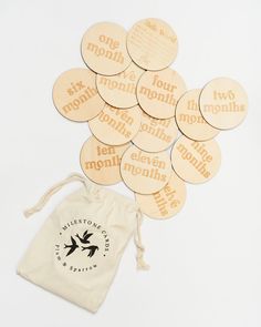 several wooden tags sitting on top of a drawstring bag next to each other