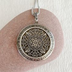 "Timeless and classic, this lovely, embossed antiqued silver locket will become a special addition to your jewelry collection. The locket is extra large at 46mm in diameter and opens for a secret place to keep pictures, messages, or whatever you like. The inside of this locket is deep and can hold two photos. The inside space is approximately 30mm in diameter. The locket is made from lightweight silver plated brass. It has been deeply embossed with an intricate pattern. It hangs on an antique si Intricate Round Pendant Locket Necklace For Anniversary, Intricate Medallion Locket Necklace For Anniversary, Anniversary Locket Necklace With Intricate Design, Vintage Silver Medallion Locket Necklace, Silver Vintage Medallion Locket Necklace, Antique Silver Sterling Silver Vintage Locket Necklace, Antique Silver Locket Necklace With Round Pendant, Vintage Antique Silver Locket Necklace Nickel Free, Vintage Antique Silver Locket Necklace For Anniversary