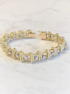 "18kt Yellow Gold Heavy Solid Lady's Cubic Zirconia (CZ) Bracelet 7\" in Length. This Bracelet consists of 18- 3mm, .10ct each , 1.80ctw Cubic Zirconia (CZ) all prong set in 14kt White Gold settings in a heavy solid 12mm wide hinged mounting. There is a hidden box clasp with a secure fig 8 safety clasp. These CZ's look so real. Total mounting weigh is 43.8 grams. This item would Retail for $6,550.00" Dazzling Gold Diamond Bracelet For Anniversary, Gold Diamond Bracelet With 17 Jewels For Anniversary, Dazzling Cubic Zirconia Gold Bracelet For Anniversary, Dazzling Gold Cubic Zirconia Bracelet For Anniversary, Gold Cubic Zirconia Bracelet With Diamond Accents For Anniversary, Gold Diamond Bracelet For Anniversary, Dazzling Gold Bracelet For Anniversary, Gold Brilliant Cut Diamond Bracelet For Anniversary, Yellow Gold Cubic Zirconia Bracelet For Anniversary