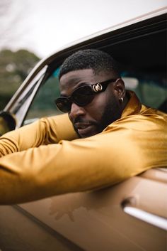 a man in sunglasses leaning out the window of a car