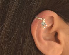 a woman's ear is shown with a star shaped piercing