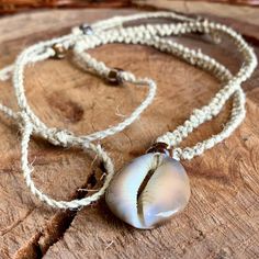 In Stock and ready to ship!  Handmade Hemp Necklace made with 100% natural colored hemp twine featuring a very unique macrame knotting and a real natural tiger cowrie (cowry) shell with glass beads.  Great beach jewelry for summertime or anytime. Real coastal, boho, hippie, laid back vibes gift idea for someone special or to treat yourself.  Featuring braided pull ties closure which makes this hemp necklace adjustable.  One size fits all.  Get it before it's gone! 🌿In stock and ready to ship the next day! 🌿Size is adjustable!  One size fits all. 🌿 About Our Hemp Jewelry: Thanks for choosing Hemp & Hook --where style meets sustainability! Here's what makes our hemp jewelry special: Sustainable Style: Our hemp jewelry is crafted with love and care using all-natural, eco-friendly hemp fibe Bohemian Macrame Necklace With Waxed Cord, Bohemian Macramé Necklace With Waxed Cord, Bohemian Adjustable Necklace For Vacation, Adjustable Waxed Cord Hippie Necklace, Adjustable Bohemian Necklace For Vacation, Casual Beach Jewelry Fair Trade, Casual Fair Trade Beach Jewelry, Hippie Macrame Beach Necklaces, Hippie Macrame Jewelry With Waxed Cord