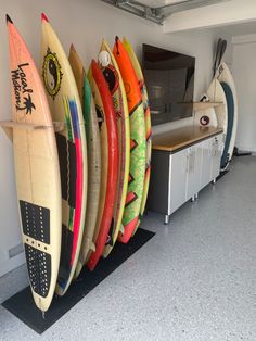 several surfboards are lined up against the wall