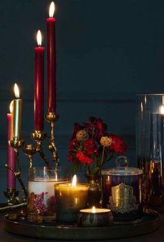 candles and flowers are arranged on a tray