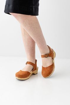 Take each step in confidence when you're wearing the 'Stockholm' clogs. They feature a closed-toe design to keep you warm, along with buckle strap for an adjustable, secure fit while walking. Neutral and easy to pair with a skirt or dress, the 'Stockholm' clogs are the perfect choice for all your fall activities! Handmade in Sweden Adjustable Round Toe Clogs With Rubber Sole, Adjustable Clogs With Rubber Sole And Round Toe, Adjustable Round Toe Clogs With Cushioned Footbed, Adjustable Clogs With Cushioned Footbed And Round Toe, Adjustable Cushioned Clogs With Round Toe, Brown Adjustable Round Toe Clogs, Adjustable Closed Toe Leather Clogs, Adjustable Round Toe Clogs, Adjustable Leather Closed Toe Clogs