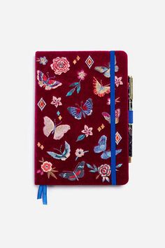 a red notebook with butterflies and flowers on it