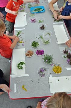 several children are sitting at a long table with plates and bowls of food on it