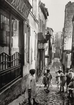 an old black and white photo of children playing in the street