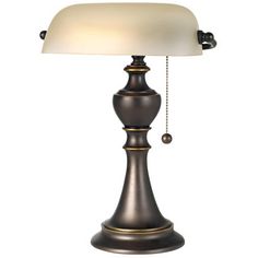 a table lamp with a white shade on it's top and chain hanging from the base